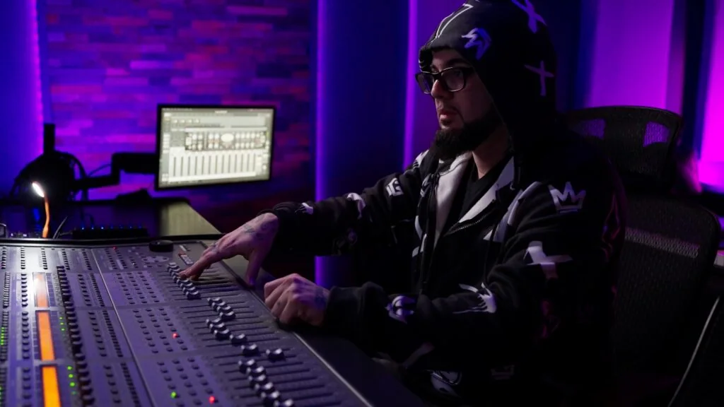 Infamous J working at the mixing desk in his studio
